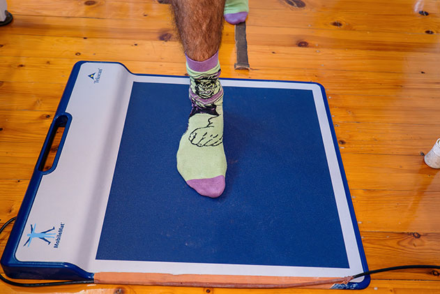 A person balances on a table while using a computer